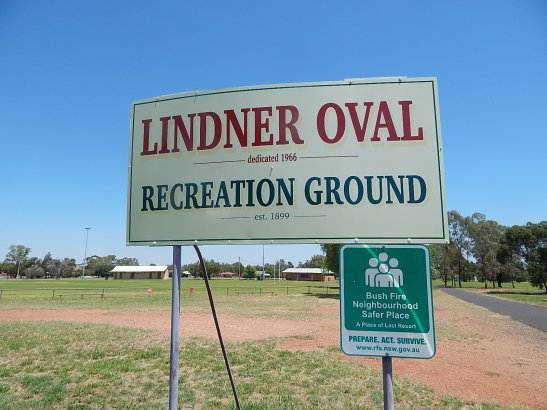 Photograph of signage at Lindner Oval, Peak Hill. Photograph by Sandie Ward (Parkes Shire Library) taken on February 10th, 2016. In the background are the changing sheds and canteen amenities buildings.