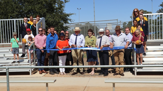 Two major infrastructure projects were showcased in Trundle - a new amenities complex at Trundle Showground; and completed upgrades to Berryman Oval. Present for the ribbon cutting was the Hon. Rick Colless, Parliamentary Secretary for Western NSW. Pictured in the photograph are (front row, left to right): Ben Howard (PSC), Peter Kelly (Trundle Progress Association), Cr Barbara Newton, Rick Colless MLC, Kate Hazelton (Nationals Candidate for Orange), Cr Ken Keith OAM, Andrew Rawsthorne (Trundle Progress Association), Gus White (Felton Industries - one of the suppliers, they did the grandstand seating). Other people in the background include Trundle Central School Students, Trundle Boomers Rugby League Football Club, Council's Presentation team, Trundle ABBA Festival. Photograph by Katrina Dwyer (Parkes Shire Council) taken on February 21, 2019.