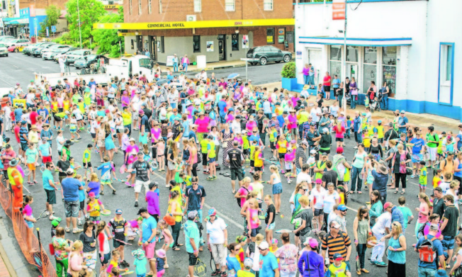 This photograph was taken from the first floor of Parkes Leagues Club looking onto the attempt at the record for most people hitting a tennis ball on a racquet at one time. Parkes now holds the record with 772 people taking part, many coming from all over the Parkes Shire. The building in white and blue is the clock tower building, and everyone assembled is on Clarinda Street. The cross street is Browne Street. This photograph was taken by Hank Paul on Saturday November 16, 2013. Source: Parkes Champion Post http://www.parkeschampionpost.com.au/story/1914815/gallery-ao-blitz-roadshow/#slide=8