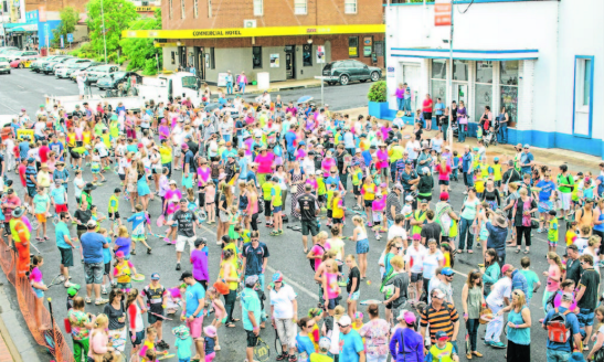 This photograph was taken from the first floor of Parkes Leagues Club looking onto the attempt at the record for most people hitting a tennis ball on a racquet at one time. Parkes now holds the record with 772 people taking part, many coming from all over the Parkes Shire. The building in white and blue is the clock tower building, and everyone assembled is on Clarinda Street. The cross street is Browne Street. This photograph was taken by Hank Paul on Saturday November 16, 2013. Source: Parkes Champion Post http://www.parkeschampionpost.com.au/story/1914815/gallery-ao-blitz-roadshow/#slide=8