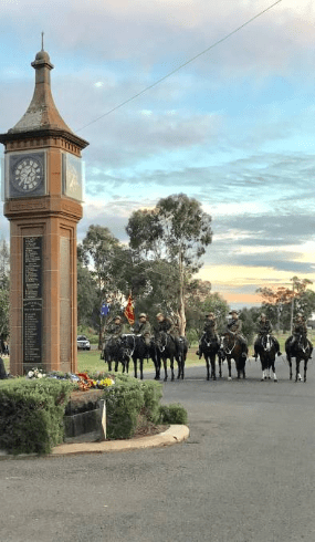 Photograph of ANZAC Day service at Bogan Gate in 2017. The Trundle Troop of the 6th Light Horse are in the background as dawn breaks. Source: Parkes Champion Post website