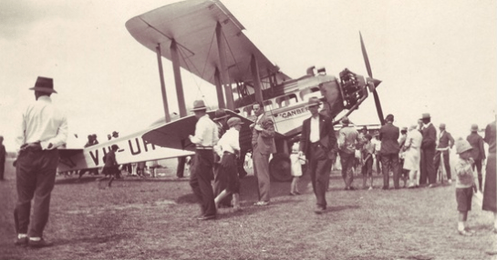 Photograph of Captain Les Holden and his de Havilland DH61 at Armidale. Captain Holden would land in paddocks and take members of the public for joy-rides. When he landed in Gilgandra, Rawdon Middleton experienced his first flight. Source: New England blog