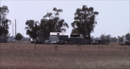 Still photograph from YouTube series Parkes Telling Tales. Nelungaloo resident, Allen Hourigan, is standing inside Nelungaloo Hall and looking at his old school buildings. Source: YouTube